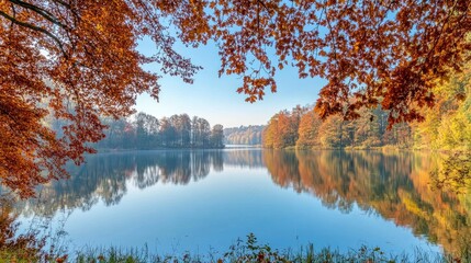 Obraz premium Autumnal lake reflection framed by colorful trees