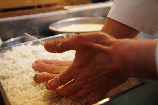 日本のとんかつ職人が豚ロースにパン粉を付けている様子