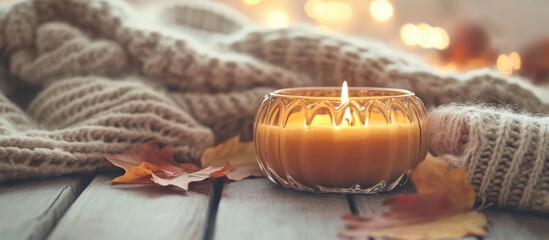 Cozy autumn decor with pumpkin candle and soft sweaters creating warm seasonal ambiance and inviting vibes for fall celebrations