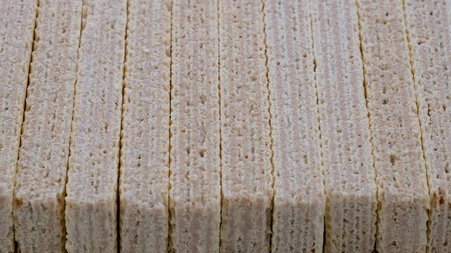 Stack of crispy wafer sticks filled white cream. Slider shot. Snacks, desserts, bakery, confectionery treats concepts. 4k