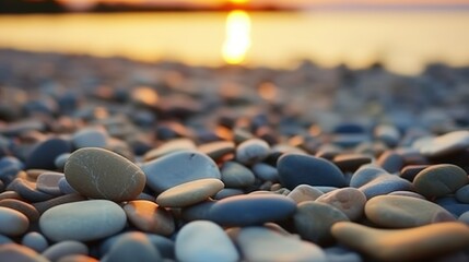 Obraz premium Tranquil Sunset Over Pebbles on a Shoreline Reflecting Golden Light with Gentle Waves in the Background