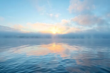 Obraz premium Serene sunrise scene. A calm lake reflects a soft, pastel sunrise sky, partially obscured by a misty fog rolling over the distant shoreline.