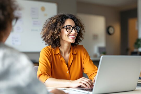 Woman in orange shirt with glasses smiling while working on laptop, modern office background, concept of productivity and workplace positivity. Ai generative
