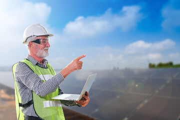 Senior engineer standing in front of metal structure at solar power construction site with laptop