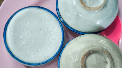 Thai dessert (khanom thuay) coconut milk custard in small porcelain cup .