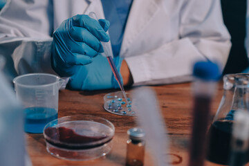 Blood test in the laboratory. Laboratory assistant working with the dispenser. Vacuum tubes with...