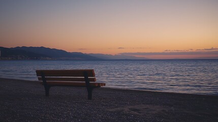A bench is sitting on the beach next to the ocean