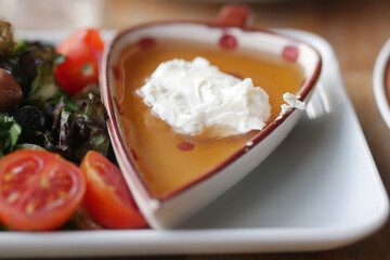 butter cream and honey in a bowl on table .