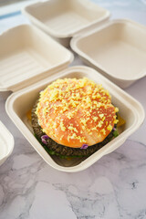 A Delicious Gourmet Burger with Cheddar Cheese in EcoFriendly Packaging