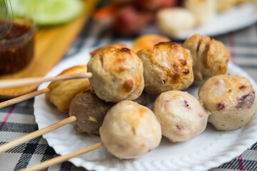 Thai street food. Meatballs on sticks served on white dish