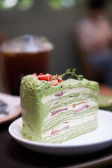 A slice of green tea layered cake with strawberry.