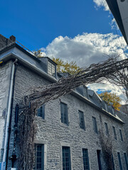 A historic stone building with classical architecture and a towering structure, captured under a partly cloudy sky.