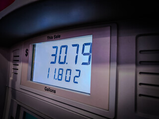 close-up of price of gas during fueling at fueling station gallons and dollars backdrop