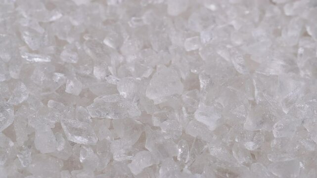 Heap of coarse rock salt crystals. Slider shot. Depth of field, selective focus. Cooking ingredients, seasoning, culinary, health, detox, spa wellness concepts. 4k