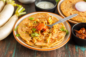 Mooli paratha is a stuffed Indian flatbread made with grated radish, whole wheat flour, and spices, offering a flavorful, nutritious, and wholesome meal.