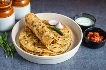 Methi paratha is a soft, flavorful Indian flatbread made with fenugreek leaves, whole wheat flour, spices, and ghee, often served with yogurt or pickle.