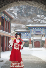 Obraz premium Asian girl wearing Chinese red Hanfu outdoors on a snowy day