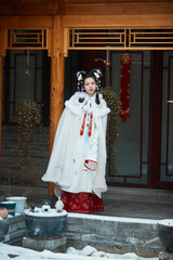 Asian girl wearing Ming Dynasty Hanfu outdoors after heavy snow