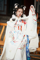 Asian girl wearing Ming Dynasty Hanfu outdoors after heavy snow