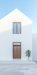 Modern white house with wooden door and minimalistic design under clear blue sky