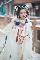 Asian girl wearing Ming Dynasty Hanfu outdoors after heavy snow