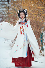 Asian girl wearing Ming Dynasty Hanfu outdoors after heavy snow