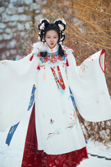 Asian girl wearing Ming Dynasty Hanfu outdoors after heavy snow