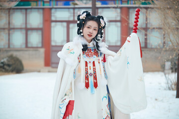 Asian girl wearing Ming Dynasty Hanfu outdoors after heavy snow
