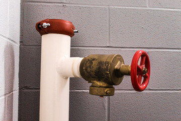 emergency fire hose standpipe system valve stairwell corridor with concrete wall background fire...