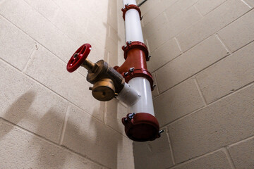 looking up view of fire hose standpipe system strategy in stairwell with concrete wall background...