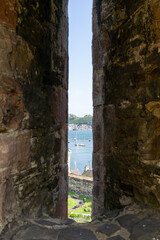 Narrow view through medieval arrow-slot in castle wall Conwy Wales