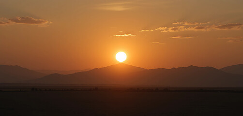 Obraz premium The rising sun casting a warm, golden glow, creating long shadows that emphasize the stillness of the moment.