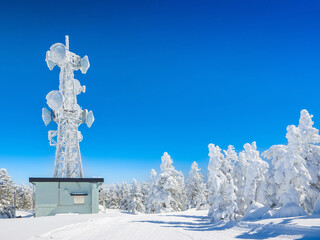 Ski slope surrounded by ice monsters with a snow-covered transmission tower on a clear day (Yokoteyama, Nagano, Japan)
