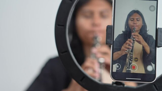 Mobile Phone Screen Filming Young Asian Musician Playing Oboe In Music Studio