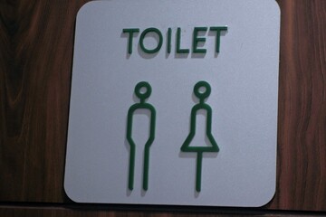 sign on a wooden door. wooden bathroom door and symbols for men and women