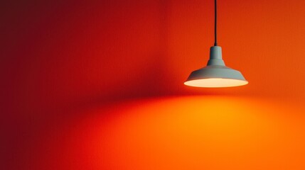 Obraz premium Modern ceiling lamp casting soft light against vibrant orange wall, creating a warm and inviting atmosphere for contemporary interior design and decor inspiration