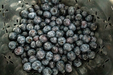 Freshly washed blueberries in a colander.