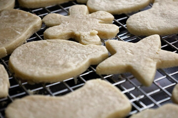 Unfrosted Christmas cookies in various shapes on a cooling rack