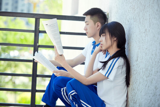 High school students reviewing and reading on the balcony of the school building