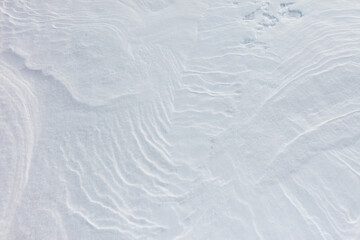 The snow is white and has a wavy texture