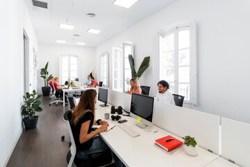 Coworkers working on computers in modern open space office