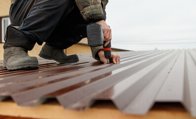A man is working on a roof with a power tool