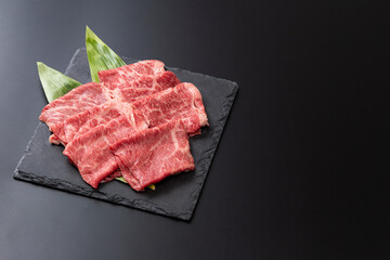 黒背景にすき焼き用の牛肩ロース肉