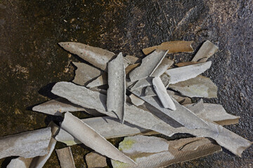 Pile of Broken Fiber Roof Shards on Rough Concrete Floor