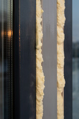 Plastic windows insulated with mounting foam. House construction