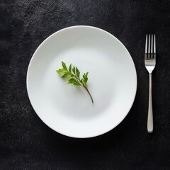 Minimalist dining scene: white plate with fresh herb on dark background anorexia eating disorder concept