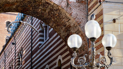 Monumental arch with hanging whale rib in Verona, Italy.Legend has it that rib will fall on righteous person who passes under.Arch della Costa.Mobile photo.