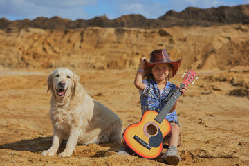 Beautiful child in a cowboy costume with a dog