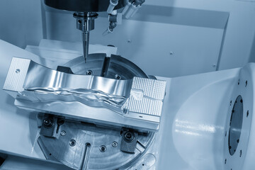 The 5-axis CNC milling machine  cutting the automotive part with solid ball end mill tool in the light blue scene.
