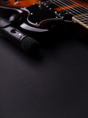 Obraz premium Microphone and electric guitar on a dark background.